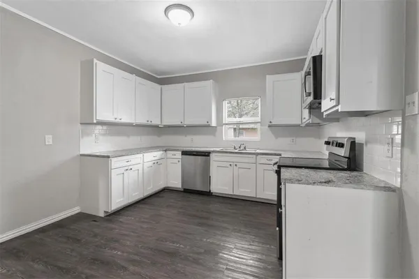 a kitchen with granite countertop white cabinets and white appliances