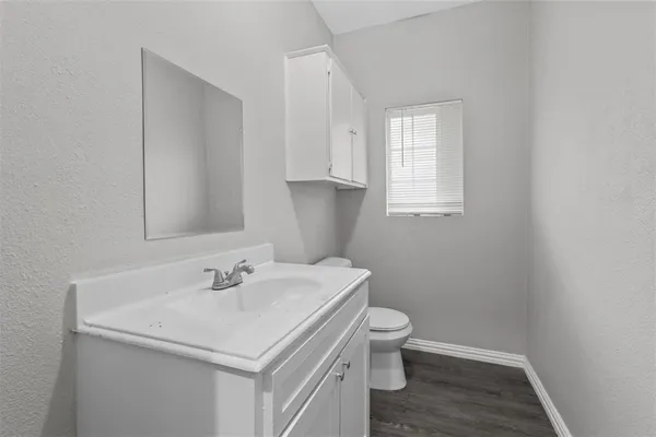 a bathroom with a sink toilet and a window