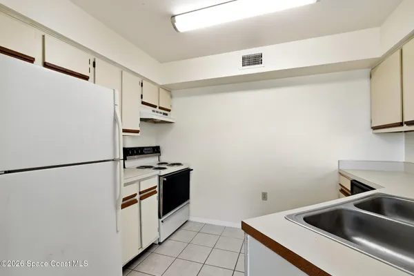 a kitchen with a refrigerator and a sink