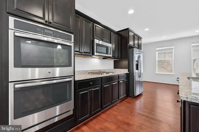 a kitchen with stainless steel appliances and granite countertop wooden cabinets