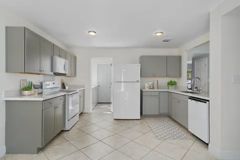 a kitchen with stainless steel appliances kitchen island granite countertop a sink and a refrigerator