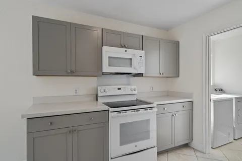 a kitchen with a sink window and white stainless steel appliances