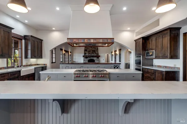 a view of a big room with wooden floor and a kitchen