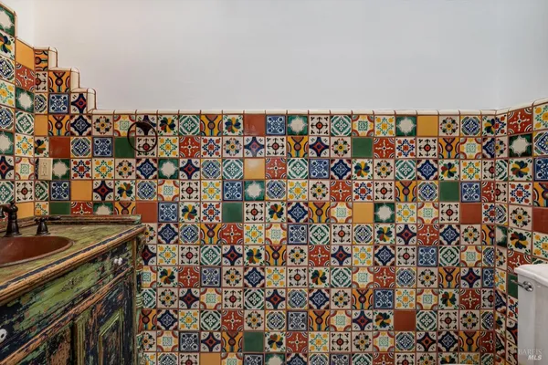 a bathroom with a granite countertop tub sink and mirror