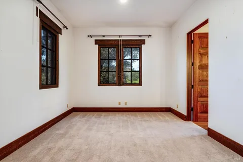 a view of an empty room with a fireplace and a window