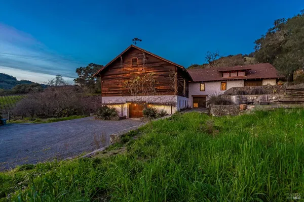 a view of a house with a lush green forest