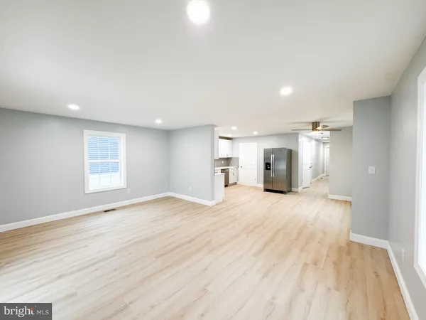 a view of empty room with wooden floor and window
