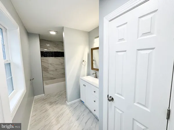 a bathroom with a sink and mirror with shower