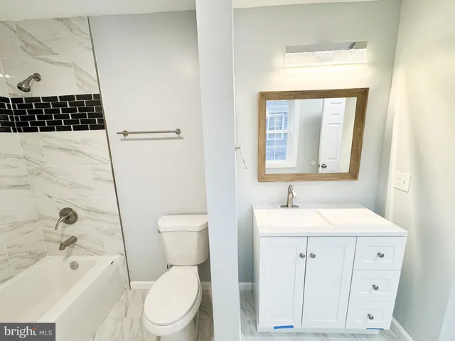 a bathroom with a sink toilet vanity and bathtub