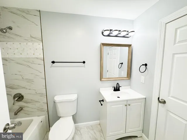 a bathroom with a toilet sink vanity and shower