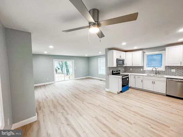 a large kitchen with cabinets wooden floor and stainless steel appliances