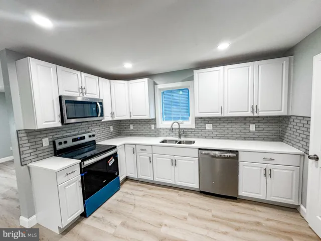 a kitchen with granite countertop a sink stainless steel appliances and cabinets