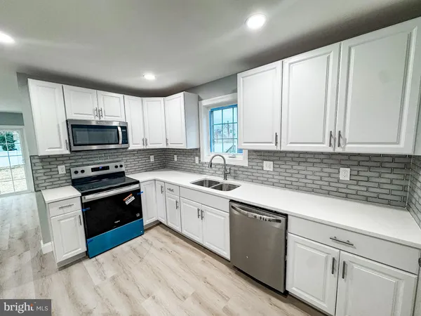 a kitchen with a sink stove and microwave