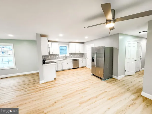 a kitchen with stainless steel appliances kitchen island granite countertop a refrigerator and a stove top oven