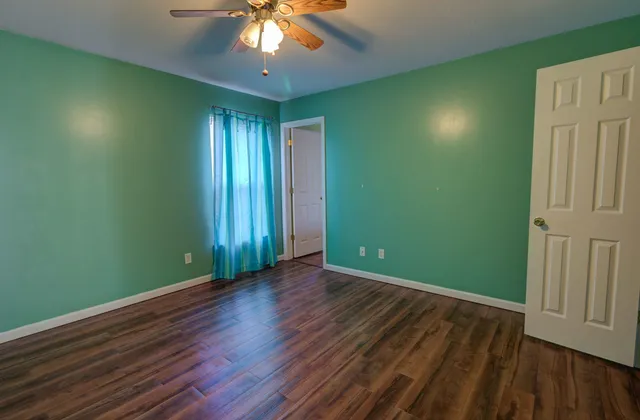 an empty room with wooden floor and closet