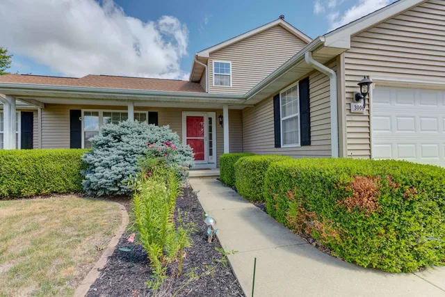 a front view of a house with a yard and potted plants