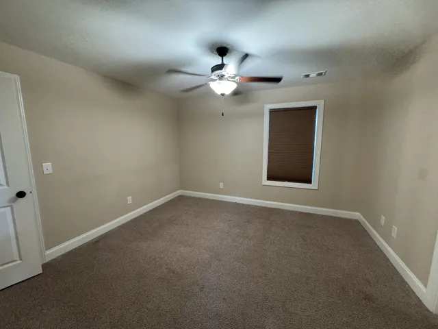 a view of a livingroom with a ceiling fan and window