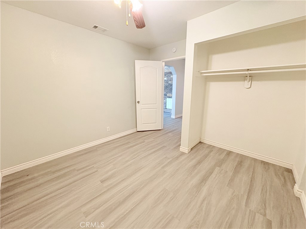 14027 Navajo Road Apple Valley, CA 92307 - Photo 12 of 25 an empty room with wooden floor closet and windows
