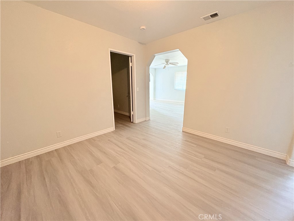 14027 Navajo Road Apple Valley, CA 92307 - Photo 18 of 25 a view of an empty room with wooden floor and a window