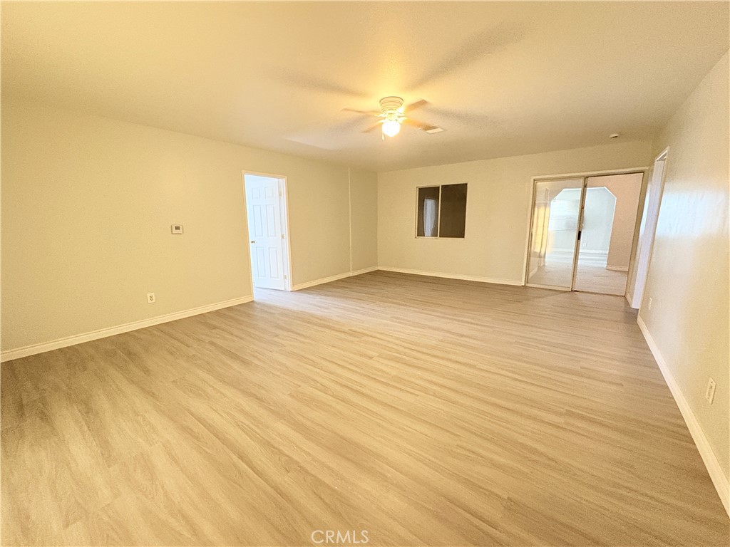 14027 Navajo Road Apple Valley, CA 92307 - Photo 19 of 25 an empty room with wooden floor and windows
