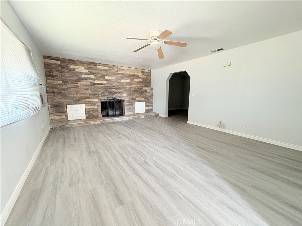 14027 Navajo Road Apple Valley, CA 92307 - Photo 2 of 25 a view of a livingroom with wooden floor and a fireplace