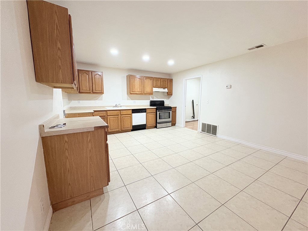 14027 Navajo Road Apple Valley, CA 92307 - Photo 5 of 25 a kitchen with stainless steel appliances granite countertop a refrigerator sink and stove