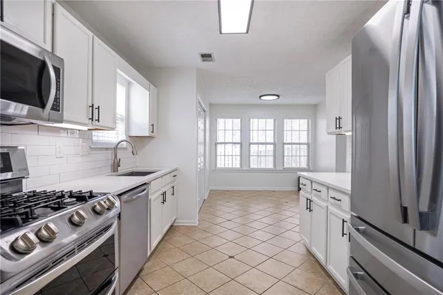 a kitchen with white cabinets and a sink
