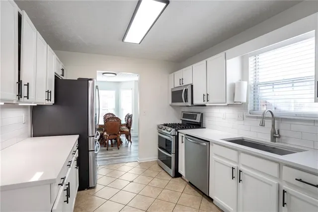 a kitchen with a refrigerator and white cabinets