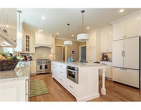 30 Robinson Road Lexington, MA 02420 - Photo 3 of 9 a kitchen with stainless steel appliances kitchen island granite countertop a stove a sink a refrigerator and white cabinets with wooden floor