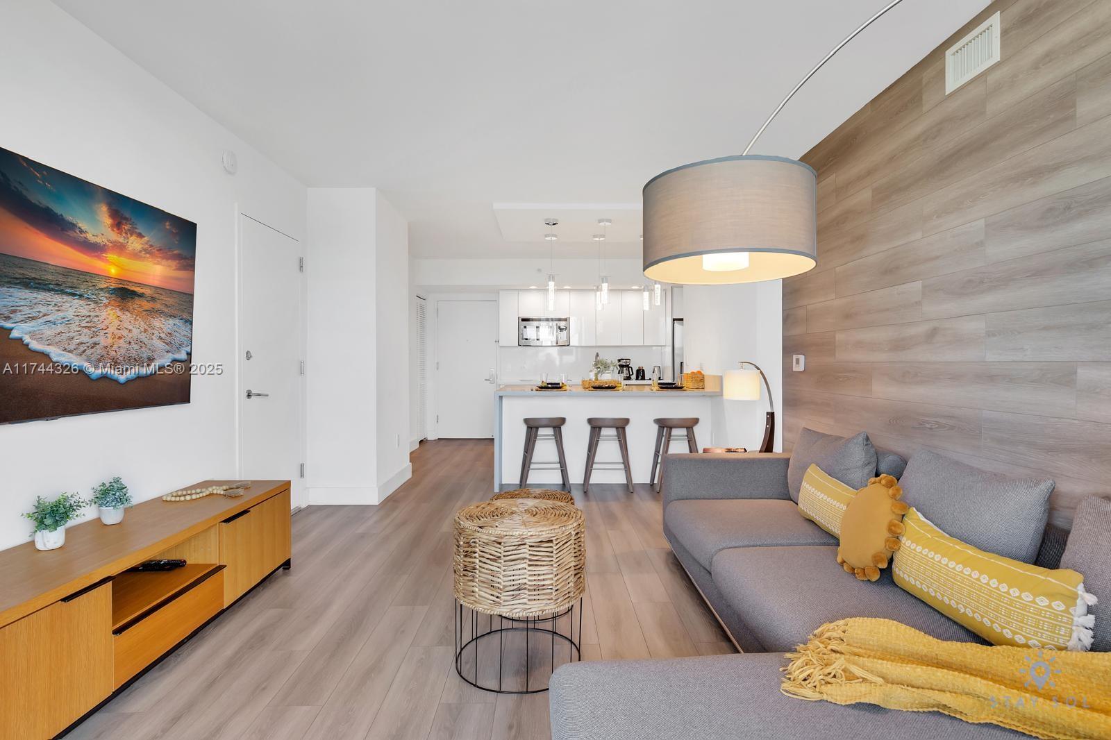 2602 East Hallandale Beach Boulevard, Unit R506 Hallandale Beach, FL 33009 - Photo 7 of 15 a living room with furniture and a flat screen tv