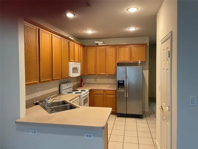 a kitchen with a sink a refrigerator and cabinets
