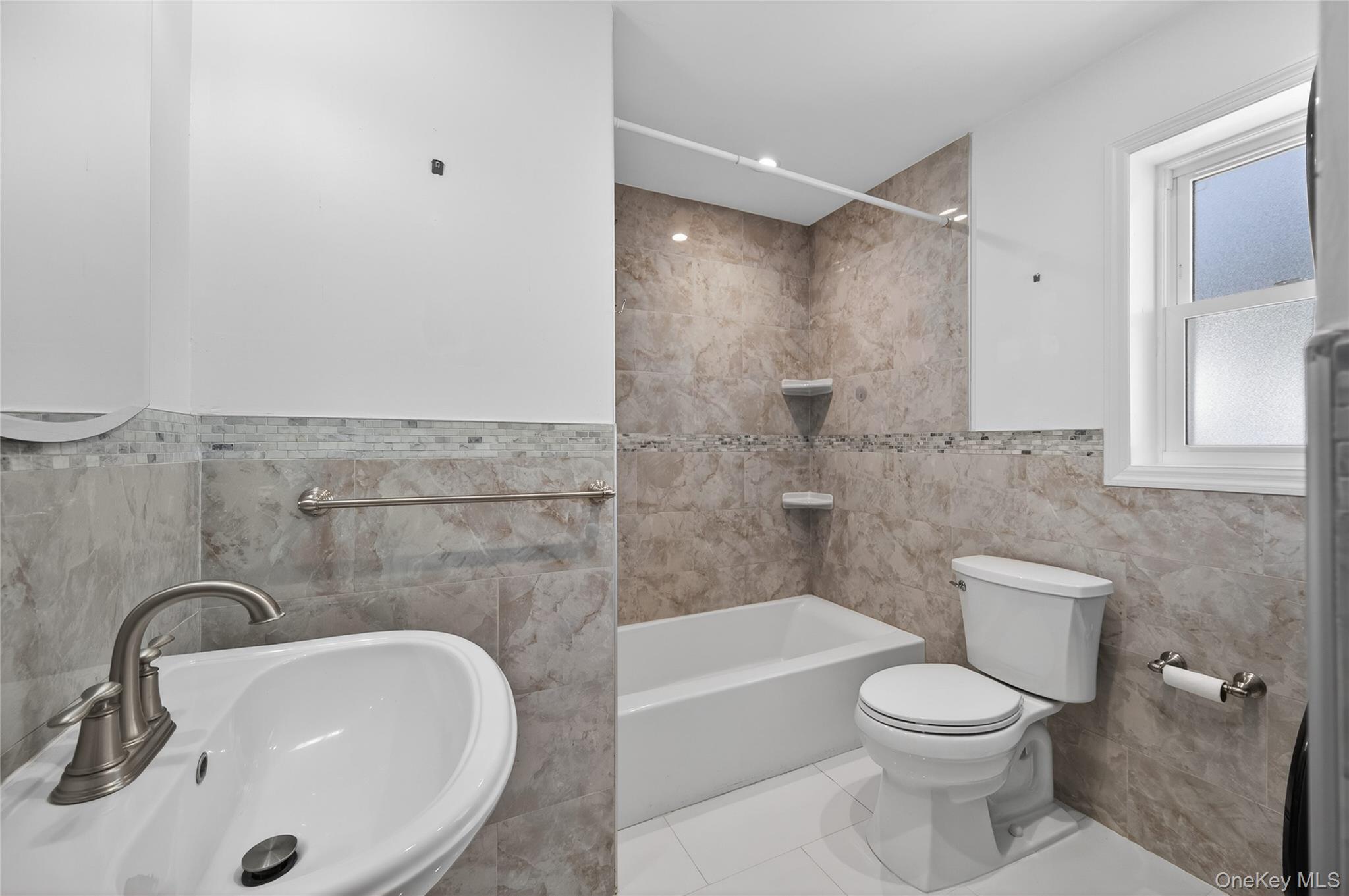 108 La Rue Drive Huntington, NY 11743 - Photo 12 of 27 Full bath with tile walls, tub / shower combination, wainscoting, and tile patterned flooring