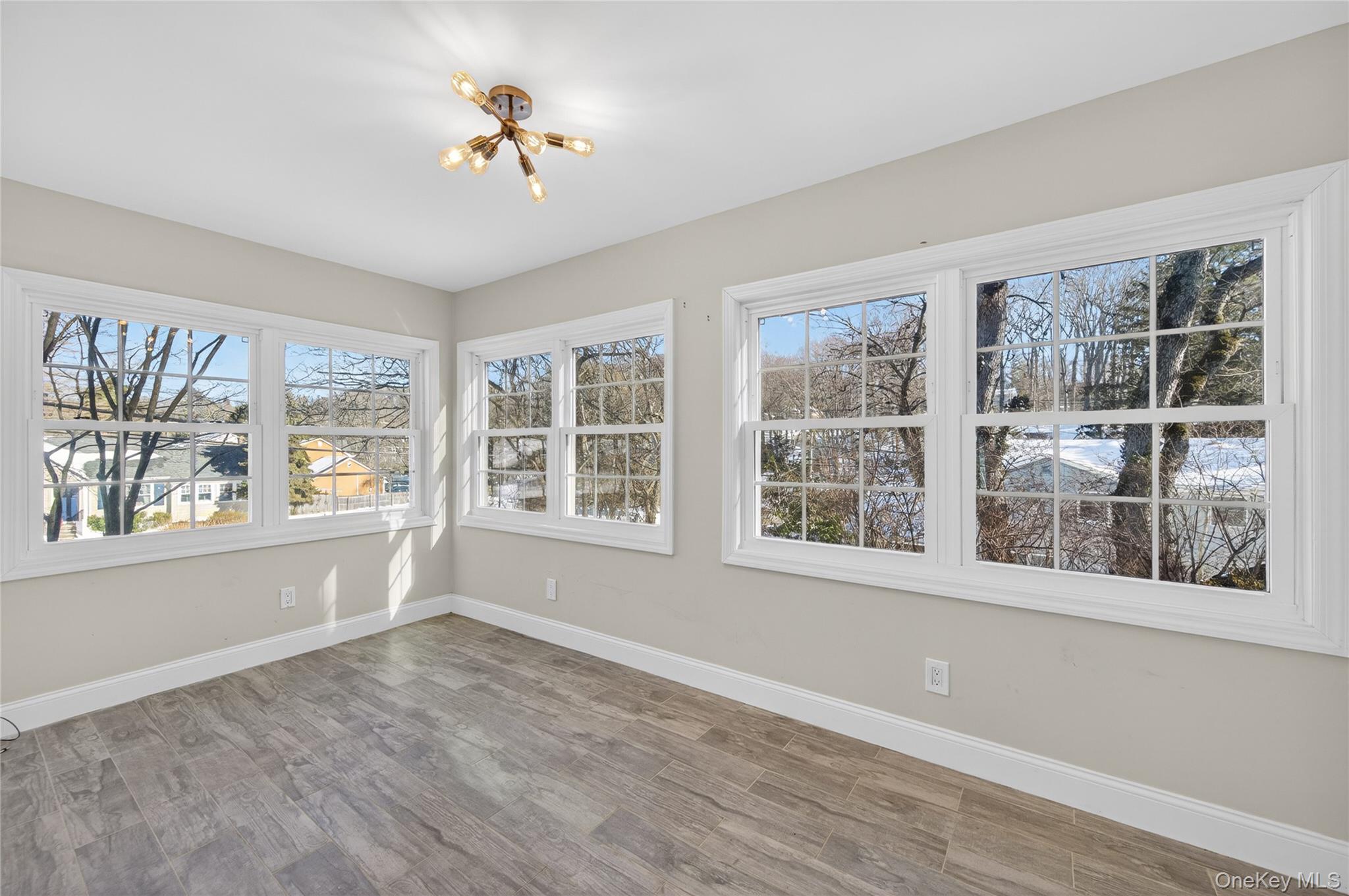 108 La Rue Drive Huntington, NY 11743 - Photo 8 of 27 Unfurnished sunroom with wood finished floors and hanging lights
