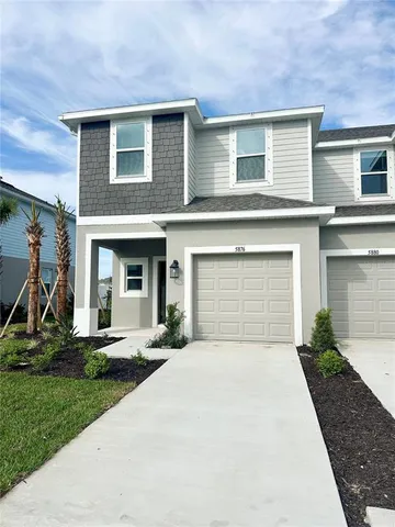 a front view of a house with a yard and trees