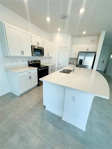 a large white kitchen with cabinets