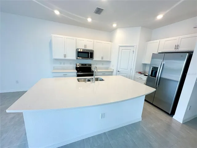 a kitchen with stainless steel appliances a refrigerator sink and microwave