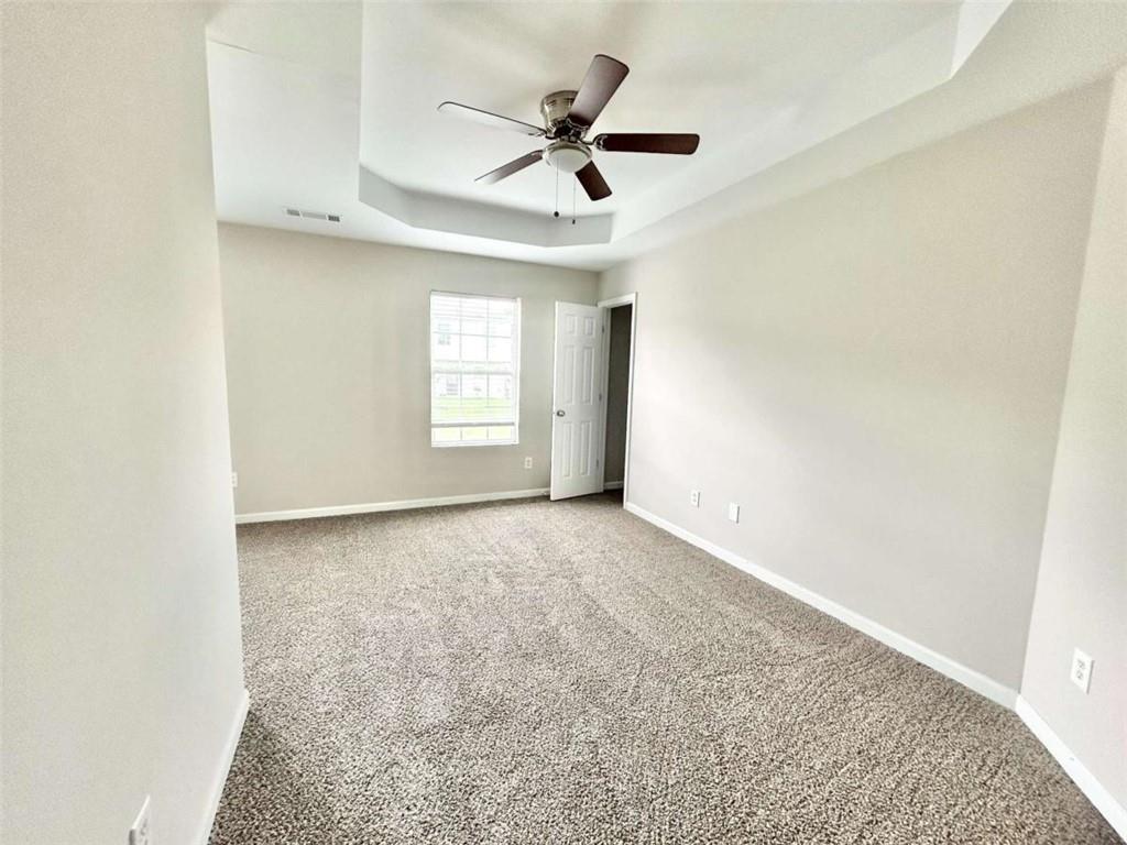 739 Wheel House Lane, Unit A Monroe, GA 30655 - Photo 12 of 17 an empty room with a ceiling fan and window