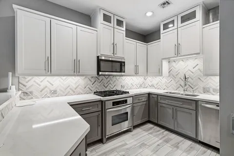 a kitchen with stainless steel appliances granite countertop a sink and a stove top oven