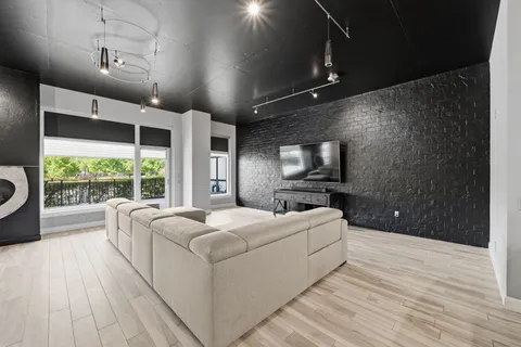 a living room with a balcony furniture and a flat screen tv