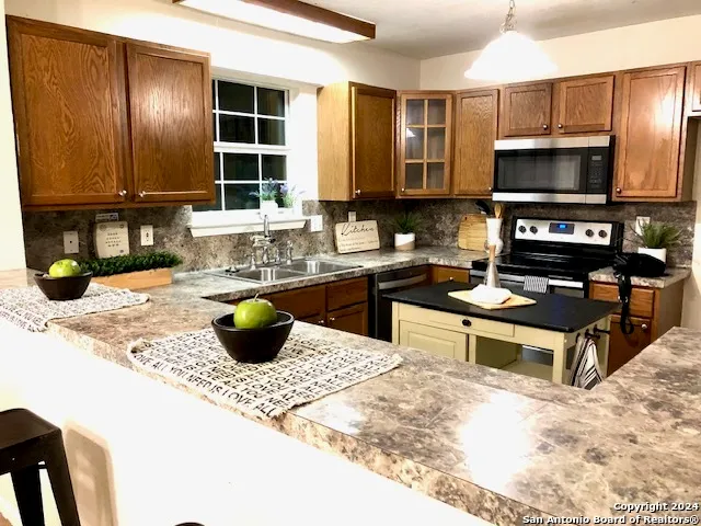 a kitchen with a stove a sink and a microwave