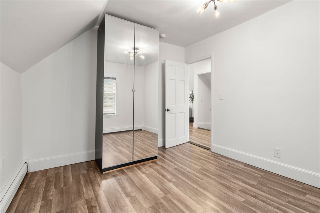 20 Pleasant View Avenue Everett, MA 02149 - Photo 20 of 22 an empty room with wooden floor and mirror