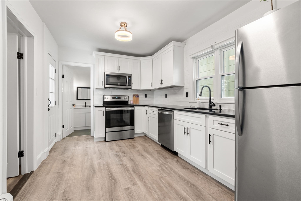 20 Pleasant View Avenue Everett, MA 02149 - Photo 4 of 22 a kitchen with white cabinets and stainless steel appliances