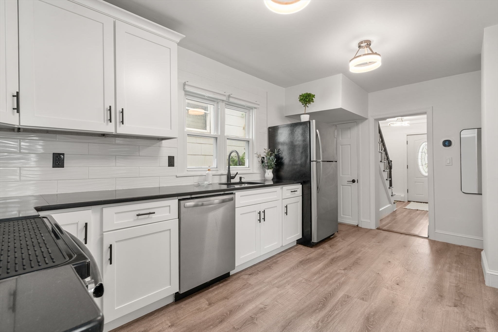20 Pleasant View Avenue Everett, MA 02149 - Photo 5 of 22 a kitchen with granite countertop a refrigerator a sink dishwasher and white cabinets with wooden floor