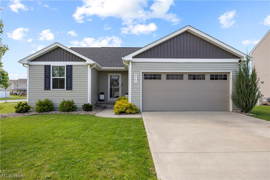 2161 Fowl Road Elyria, OH 44035 - Photo 1 of 46 Contemporary ranch-style home featuring light gray siding with dark gray accents, a concrete driveway, an attached garage with window inserts, a front walkway, and foundational landscaping