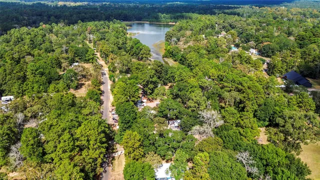 an aerial view of residential house with outdoor space and trees all around
