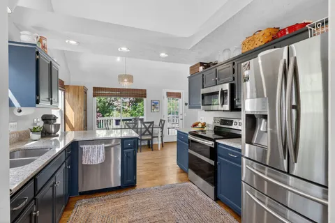 a kitchen with stainless steel appliances granite countertop a refrigerator stove microwave and sink