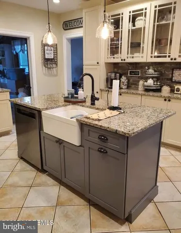 a kitchen with granite countertop a refrigerator and a stove top oven