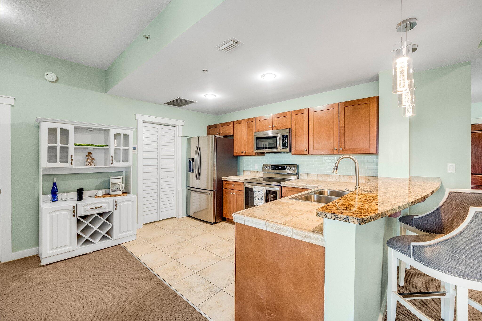 15100 Front Beach Road, Unit 517 Panama City Beach, FL 32413 - Photo 11 of 21 a kitchen with stainless steel appliances granite countertop a sink stove and refrigerator