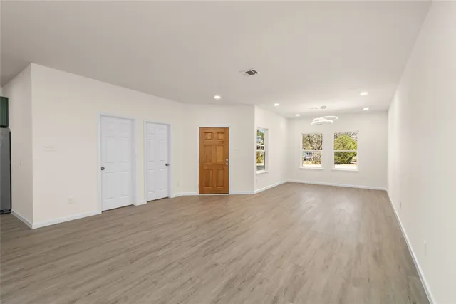 an empty room with wooden floor and ceiling fan