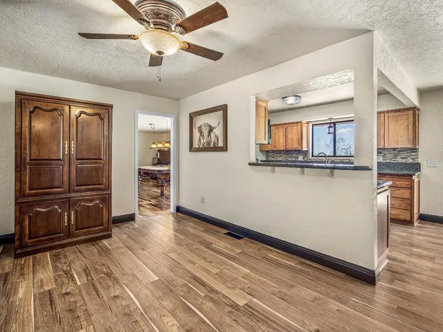 a view of a kitchen with wooden floor and a ceiling fan